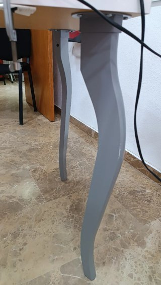 Mesa blanca de madera con patas curvas.