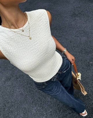 Camisa blanca texturizada con collares dorados