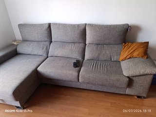 Sofá modular gris con cojín naranja