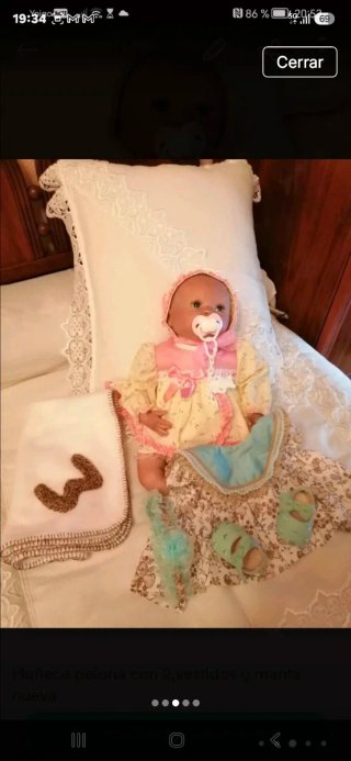 Muñeca bebé con 2 vestidos y manta.