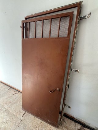 Puerta de hierro marrón con reja