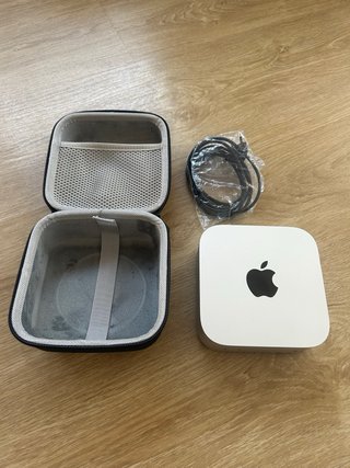 Mac mini M4 con funda y cargador.