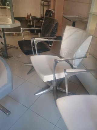 Sillones de peluquería plateados y blancos