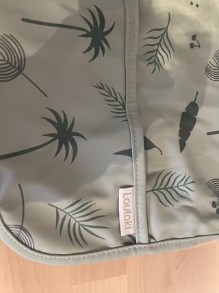 Babero impermeable con mangas y bolsa.