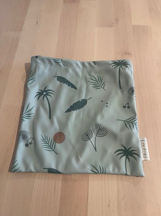Babero impermeable con mangas y bolsa.