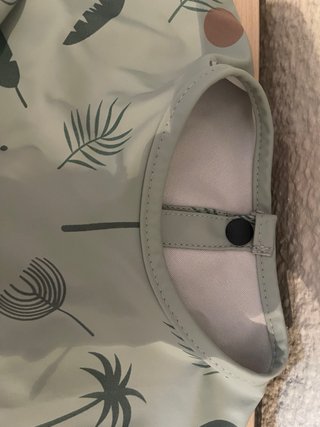 Babero impermeable con mangas y bolsa.