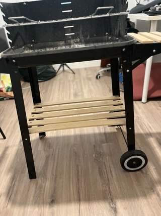 Barbacoa negra con ruedas y madera