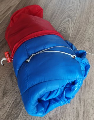Saco de dormir azul con funda roja.