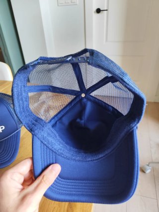 Dos gorras azules con texto ANOTHER MERCH CAP
