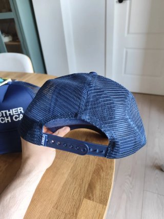 Dos gorras azules con texto ANOTHER MERCH CAP
