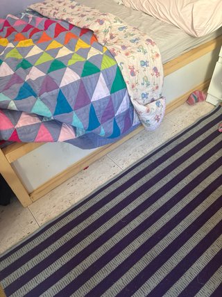 Cama individual de madera con textiles