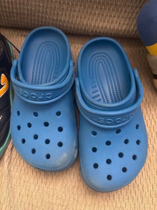 Crocs azules y chanclas negras