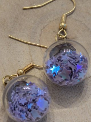 Pendientes colgantes dorados con detalles morados