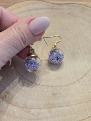 Pendientes colgantes dorados con detalles morados