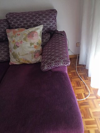 Sofá morado pequeño con cojín floral
