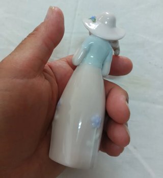 Bambina in porcellana con fiori e cestino