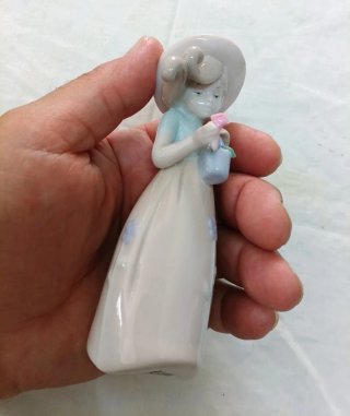 Bambina in porcellana con fiori e cestino