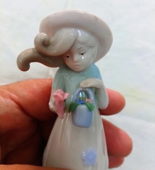 Bambina in porcellana con fiori e cestino