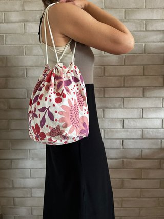 Bolso blanco tipo saco con estampado de flores.