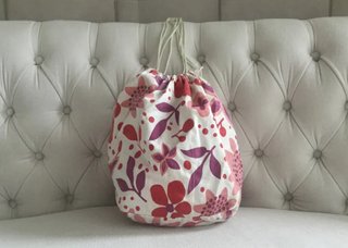 Bolso blanco tipo saco con estampado de flores.