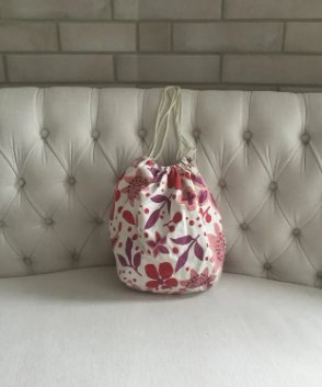 Bolso blanco tipo saco con estampado de flores.