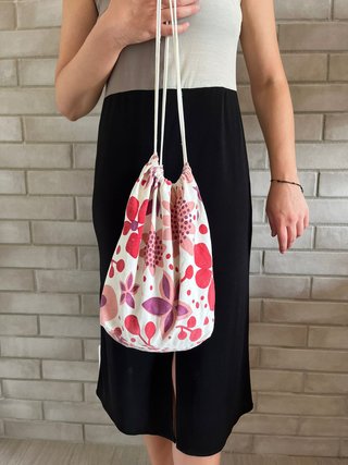 Bolso blanco tipo saco con estampado de flores.