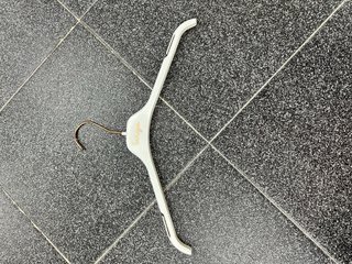 Perchas blancas y doradas de plástico.