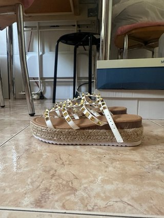 Sandalias planas blancas con tachuelas doradas