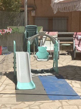 Parque infantil con tobogán y columpio