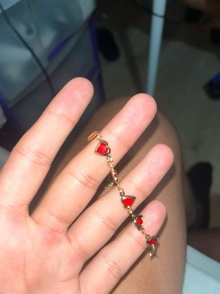 Pulsera dorada con corazones rojos