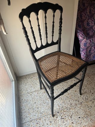 Silla de madera negra con asiento de ratán