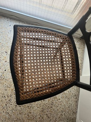 Silla de madera negra con asiento de ratán