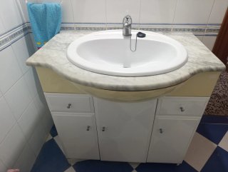 Lavabo con grifo y encimera de mármol.