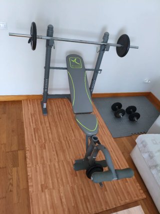 Banco de gimnasio con barra y discos