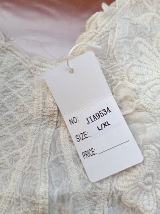 Top blanco bordado estilo boho con etiqueta