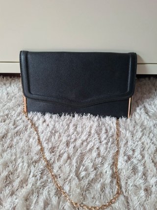 Bolso de mano negro con cadena dorada
