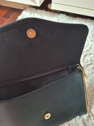 Bolso de mano negro con cadena dorada