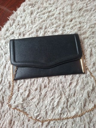 Bolso de mano negro con cadena dorada