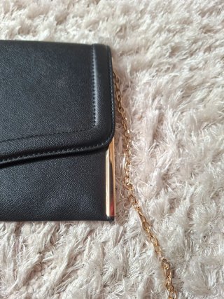 Bolso de mano negro con cadena dorada