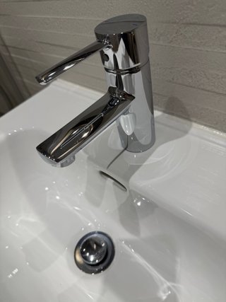 Mueble de baño blanco con grifo
