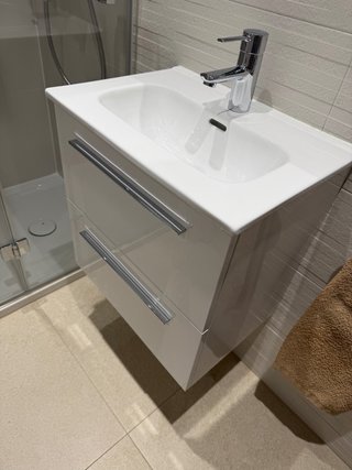 Mueble de baño blanco con grifo