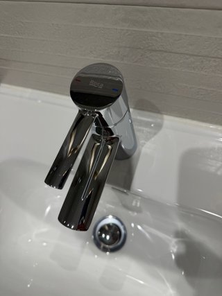 Mueble de baño blanco con grifo