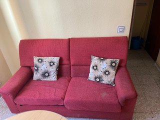 Sofá de tela rojo con cojines