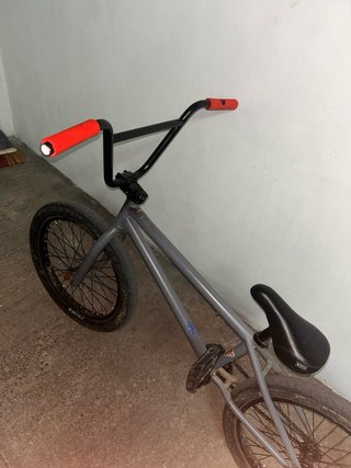 Bicicleta BMX gris con ruedas negras