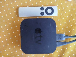 Apple TV con mando y cables HDMI