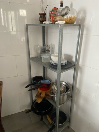 Scaffale metallico con utensili da cucina