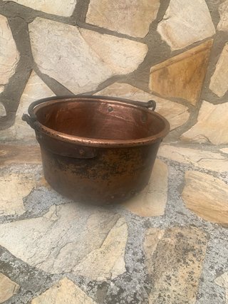 Caldera de cobre antigua con cesta.