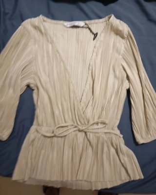 Camisa beige plisada con lazada
