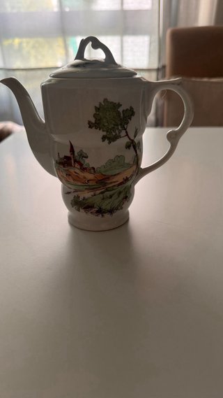 Tetera antigua de porcelana con paisaje