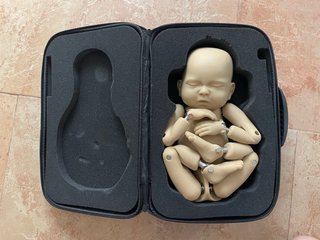 Maniquí bebé articulado con maletín